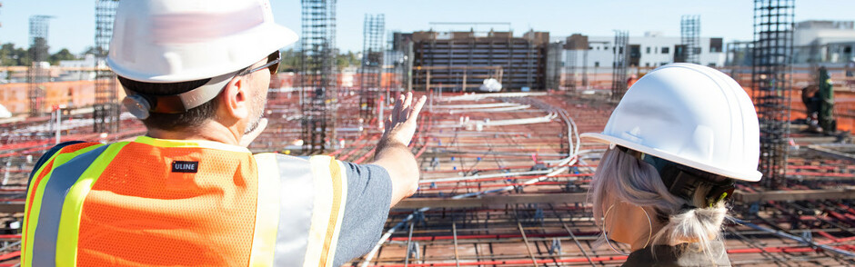 Consultant advising client while overlooking the construction site